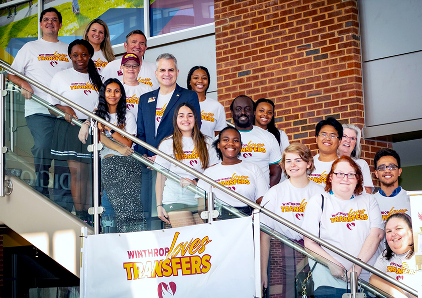 Winthrop President Edward Serna with a group of transfer students standing on the
                  steps in the student center