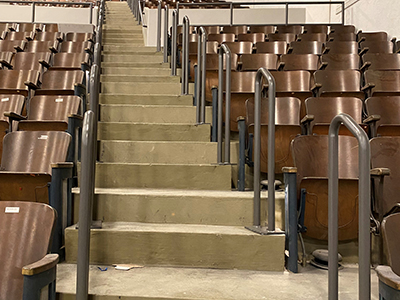 Brown auditorium chairs on either side of a staircase