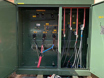 Green box showing wires plugged into an electrical outlet