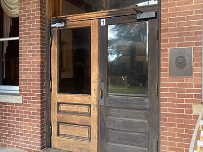 Wooden doors with glass windows attached to brick building