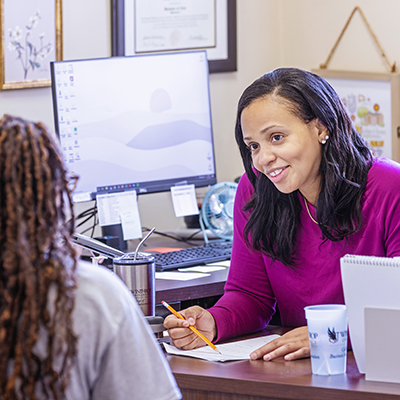 a student and professor meeting in her office