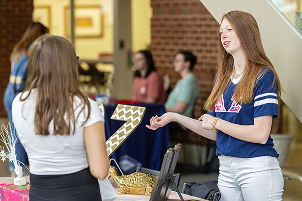 a student talking to a sorority member during a tabling event in the student center