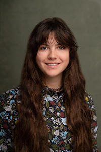 Portrait of a woman with long brown hair wearing a floral blouse