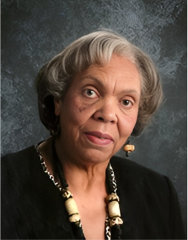 Professional headshot of a woman in a black blouse wearing jewelry