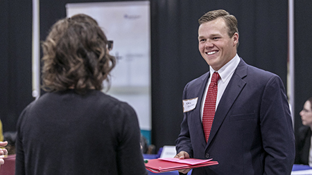 A man and woman in business attire networking at a conference