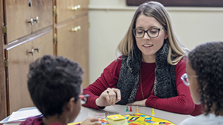 A student playing a game with two young children