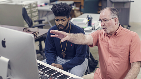 A professor and student working in a computer music lab