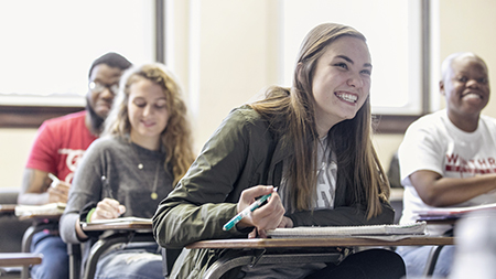 Smiling students at classroom desks