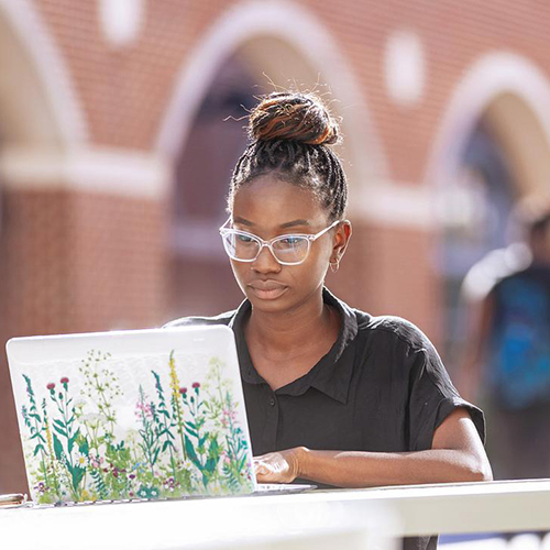 A student typing on a laptop