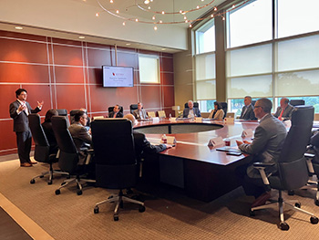 Gary Simrill giving a presentation to a group of executives around a conference room
            table